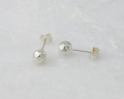 Silver hammered stud earrings on white marble