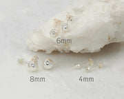 Silver hammered stud earrings in size 4mm, 6mm, and 8mm on white marble