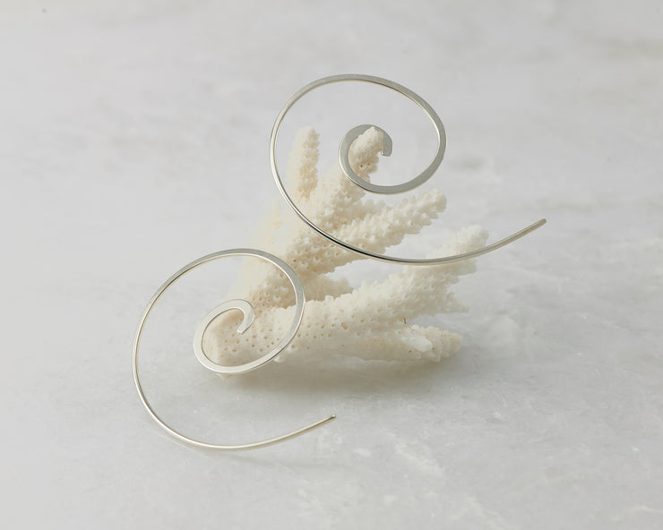 silver swirl threader earrings on coral