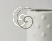 silver swirl threader earrings on dotted vase