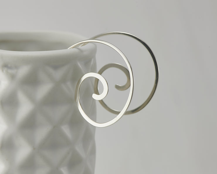 silver swirl threader earrings on geometric vase