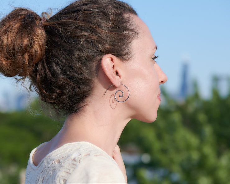 woman wearing silver swirl threader earrings