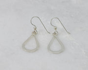 Silver polished teardrops earrings on white marble