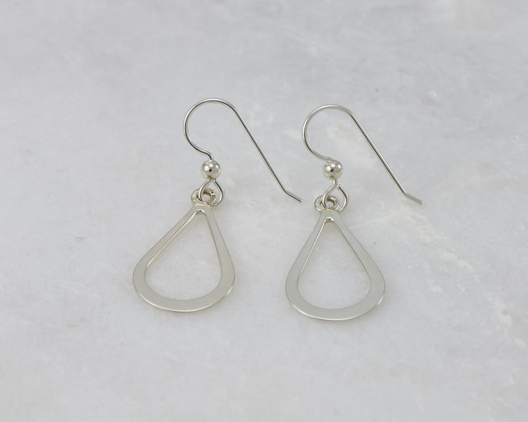 Silver polished teardrops earrings on white marble