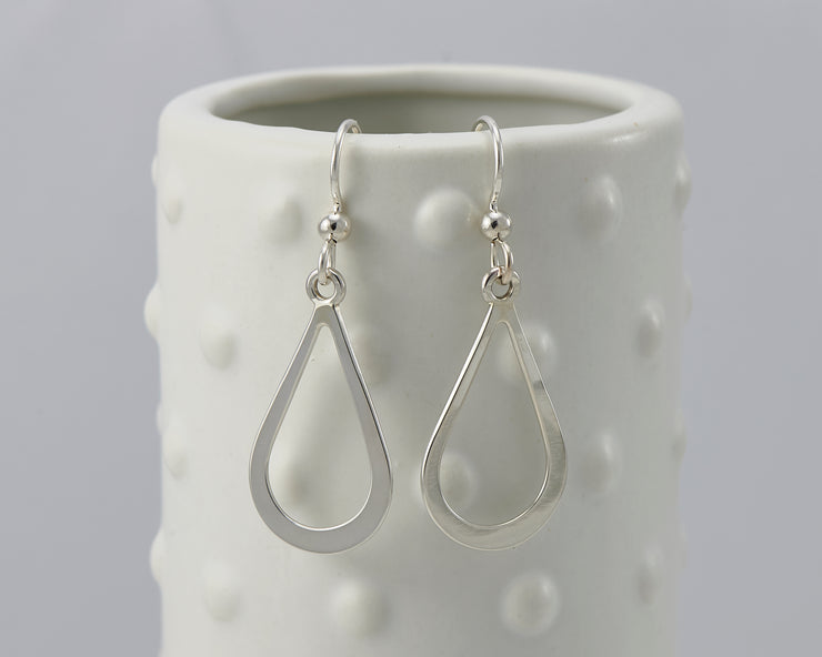 Silver teardrops earrings on dotted vase