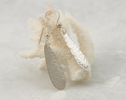 Silver teardrops earrings on coral