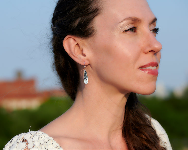 Woman wearing silver teardrops earrings