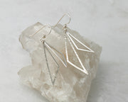 Silver triangle earrings on crystal rock