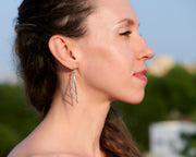 Woman wearing silver triangle earrings