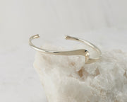 Silver wave cuff bracelet on white rock