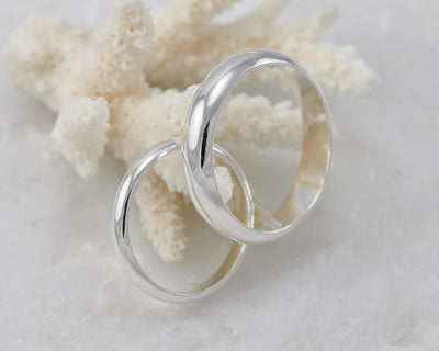 his and hers silver wedding band set on coral