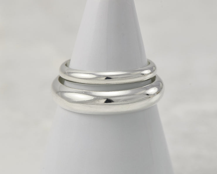 two silver polished wedding rings on white ring holder