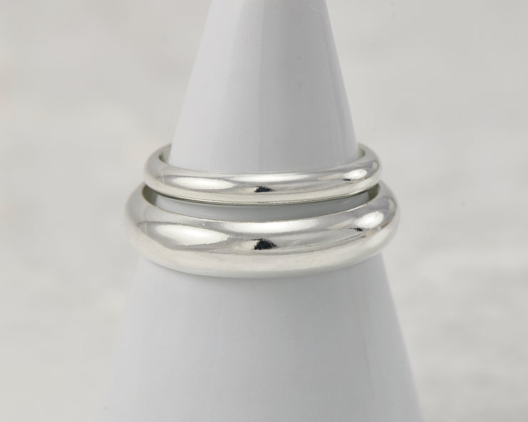two silver wedding bands on white ring holder