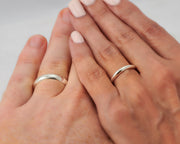Man and woman holding hands wearing silver wedding bands