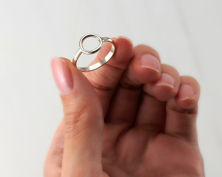 woman holding silver circle ring