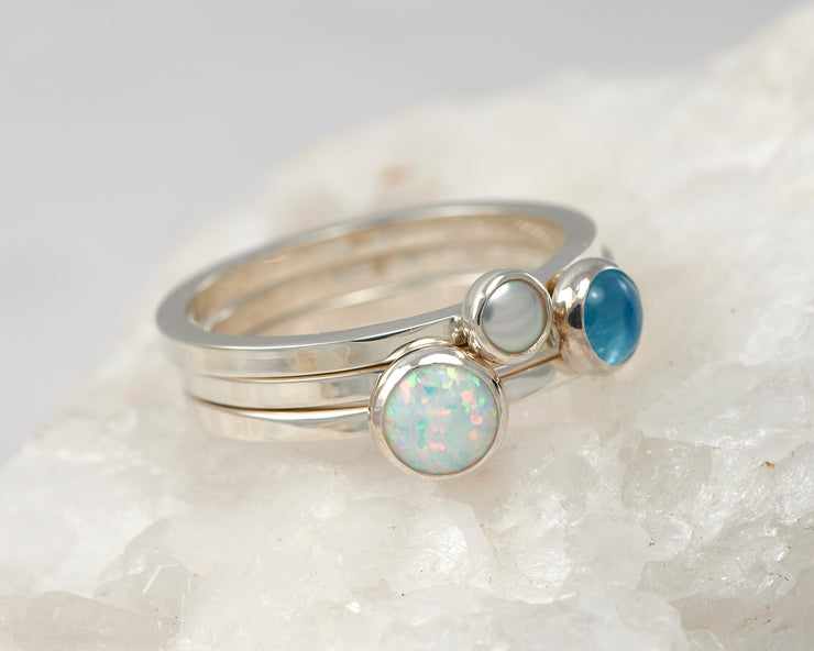 silver stacking rings opal, pearl, blue topaz on white rock