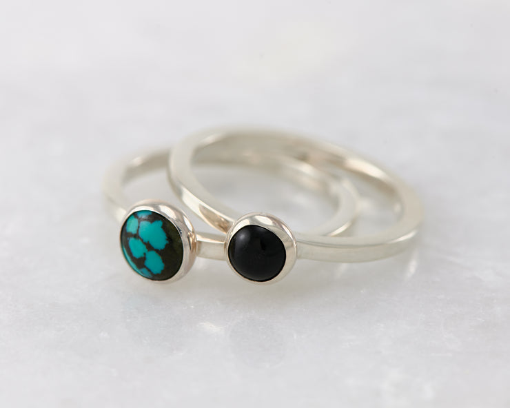 turquoise and black onyx silver stacking rings on white marble