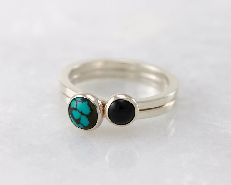 simple turquoise and black onyx silver stacking rings on white marble