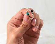 woman holding turquoise & black onyx stacking rings