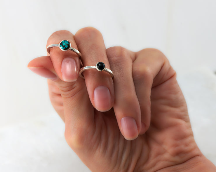 woman holding turquoise & black onyx stacking rings