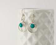 Silver turquoise hoop earrings on geometric vase