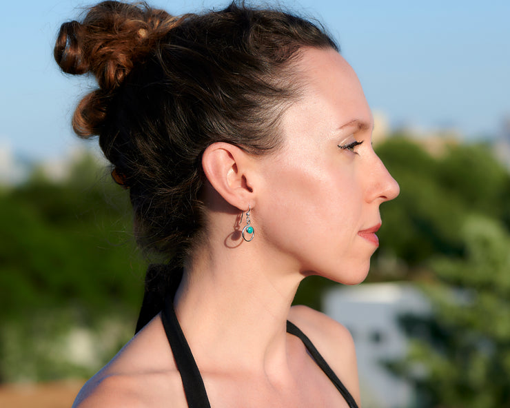 Woman wearing silver turquoise hoop earrings