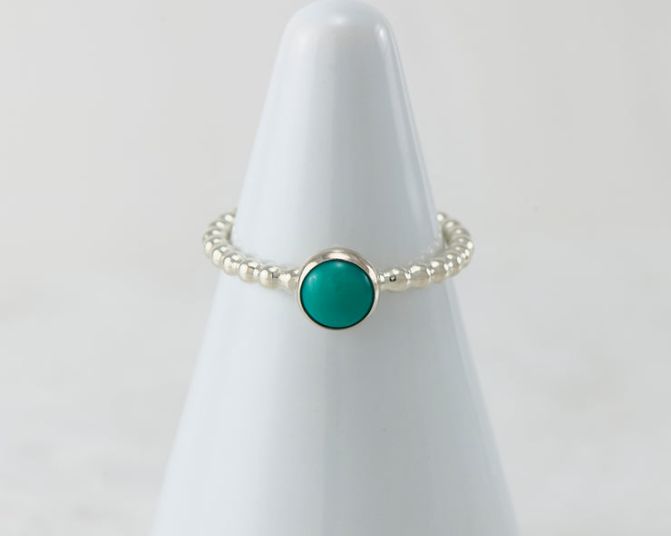 White ring holder with turquoise Silver ring