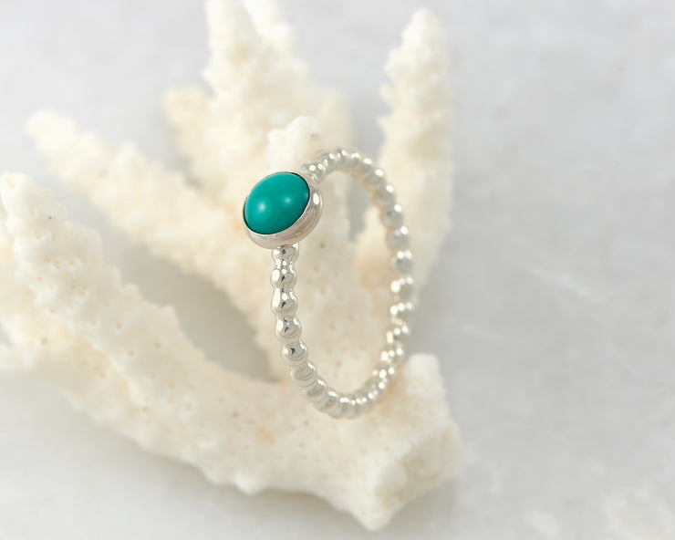 Silver turquoise ring on coral