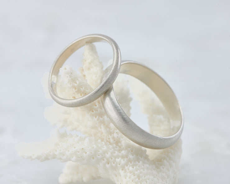 his and hers brushed wedding band set on coral