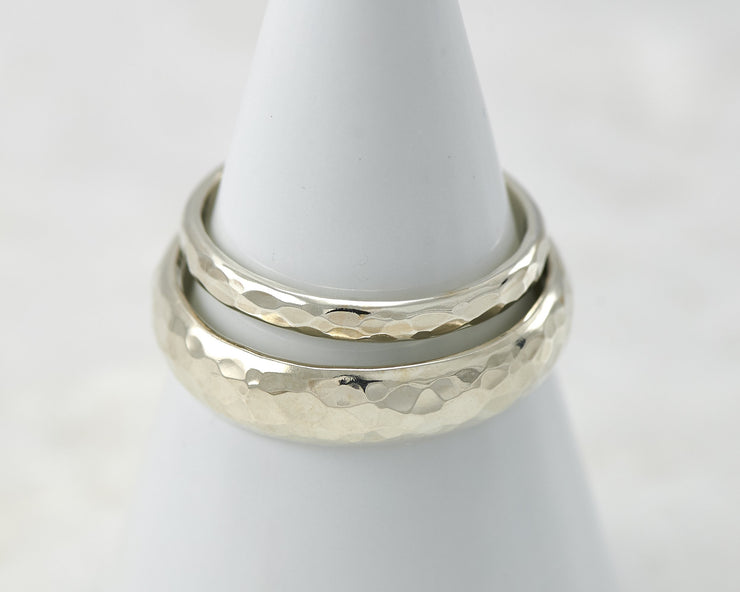 two hammered wedding rings on white ring holder