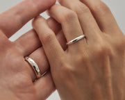 Man and woman holding hands wearing wedding rings