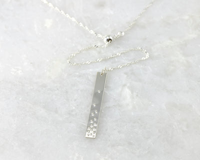 silver bar y-necklace on white marble