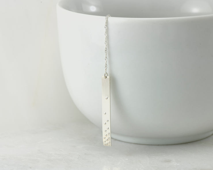 silver bar y-necklace on white cup